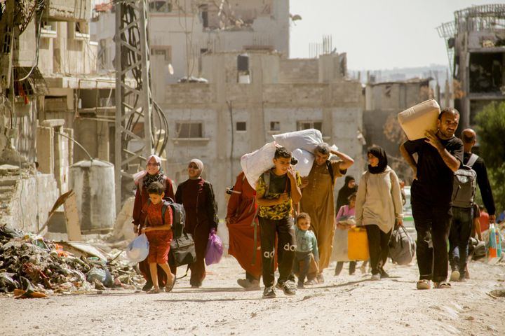 Palestinians carry their belongings as they flee areas north of Gaza City on October 12, 2024. In recent days, the Israeli military has launched an intense ground and air assault in northern Gaza, particularly in and around the city of Jabalia.